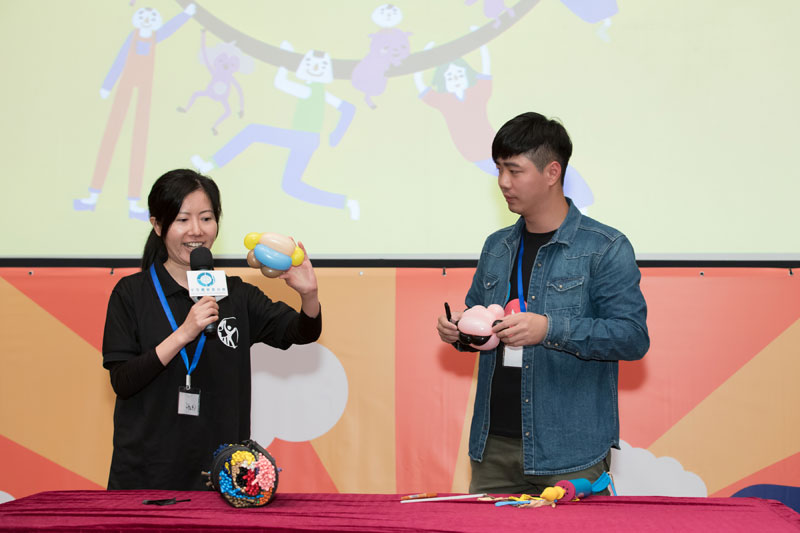 YM Balloon聽障氣球藝術師何炯灼先生一邊扭著粉紅和黑色的氣球，一邊用手語向觀眾講解，造型是根據《高仔與朋友們》的角色設計。手語翻譯員在左邊拿著另一個氣球，用口語翻譯。
